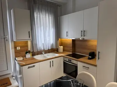 a kitchen with white cabinets and a sink at My house apartment jp in Athens