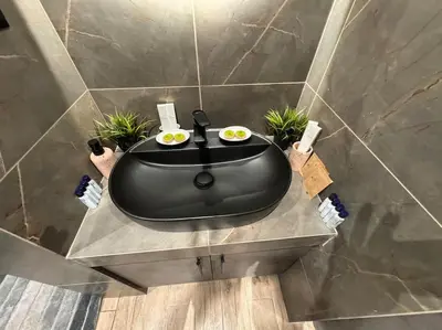 a black bath tub sitting on a table in a bathroom at My house apartment jp in Athens