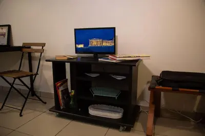a tv sitting on top of a black table at Angel - Cozy, renovated, studio in Athens heart in Athens