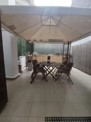 a patio with a table and chairs under an umbrella at Angel's Yard in Athens Heart in Athens