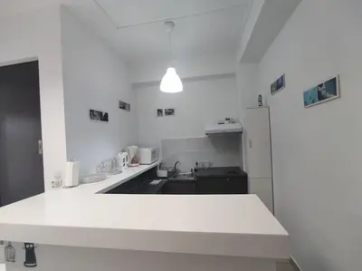 a white kitchen with a sink and a counter top at Angel's Yard in Athens Heart in Athens