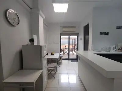 a white kitchen with a refrigerator and a counter top at Angel's Yard in Athens Heart in Athens