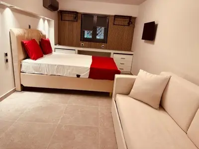 a bedroom with a bed with red pillows and a couch at Loft Athens 1 - 55m2 in Athens