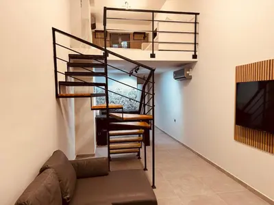 a spiral staircase in a living room with a couch at Loft Athens 1 - 55m2 in Athens
