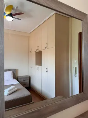 a mirror reflecting a bedroom with a bed and a ceiling fan at La Maison in Áyios Nikólaos