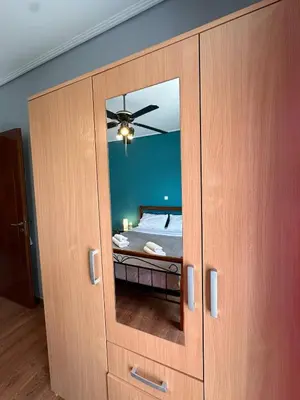 a large wooden cabinet with a mirror in a bedroom at La Maison in Áyios Nikólaos