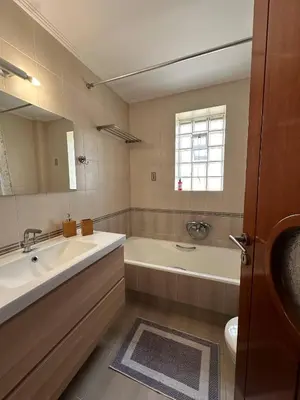 a bathroom with a tub and a sink and a bath tub at La Maison in Áyios Nikólaos