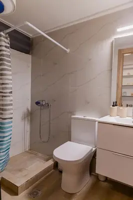 a white bathroom with a toilet and a shower at Sweet greek memories C in Athens
