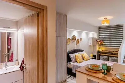 a room with a bed and a kitchen with a table at Sweet greek memories C in Athens