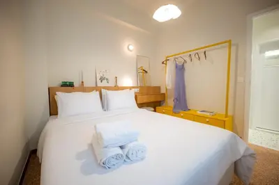 a bedroom with a white bed with towels on it at Aegis Filoppapou suites - Olive in Athens