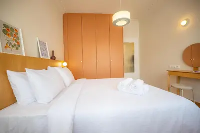 a bedroom with a large white bed with towels on it at Aegis Filoppapou suites - Olive in Athens