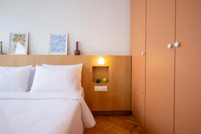 a bedroom with a white bed and a cabinet at Aegis Filoppapou suites - Olive in Athens