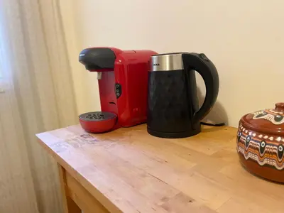 a red and black coffee maker sitting on a wooden table at Saronida Beach Nest Apartment in Saronida