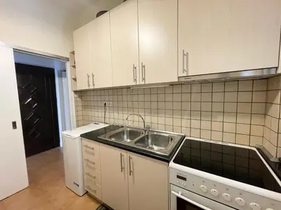 a kitchen with a sink and white cabinets at Saronida Beach Nest Apartment in Saronida
