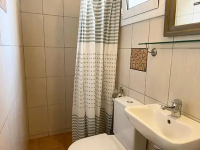 a small bathroom with a toilet and a sink at Saronida Beach Nest Apartment in Saronida
