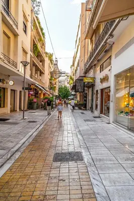 an empty street with people walking down the street at Stay at Premium Syntagma Location in Athens