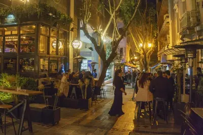 a group of people walking down a street at night at Stay at Premium Syntagma Location in Athens
