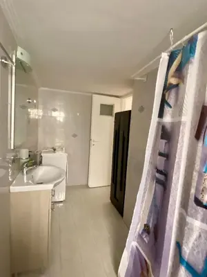 a white bathroom with a sink and a toilet at Kalamaki Philoxenia in Athens