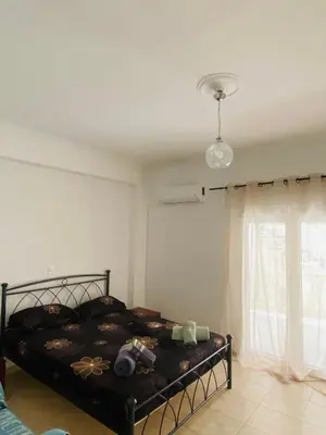 a bedroom with a bed and a window at Kalamaki Philoxenia in Athens