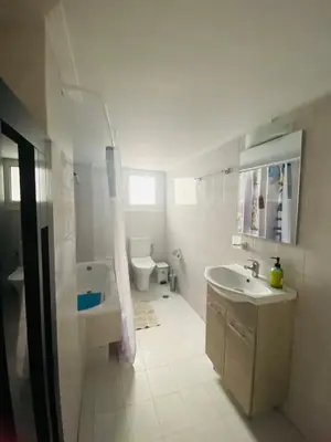 a white bathroom with a sink and a toilet at Kalamaki Philoxenia in Athens