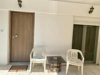 two chairs and a table in front of a door at Kalamaki Philoxenia in Athens