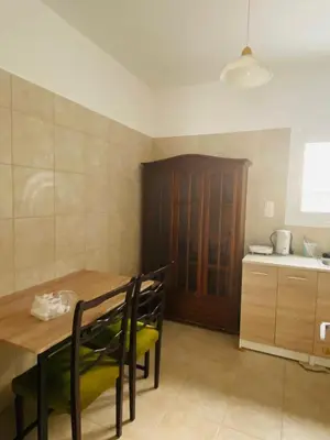 a kitchen with a wooden table and chairs in a room at Kalamaki Philoxenia in Athens