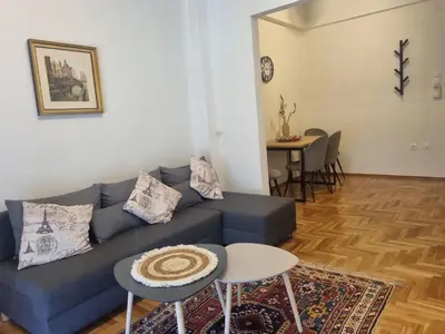 a living room with a blue couch and a table at Apartment with a view in Athens in Athens