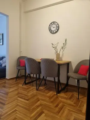 a dining room table with chairs and a clock on the wall at Apartment with a view in Athens in Athens