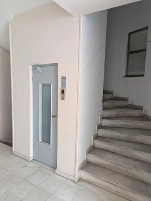 a hallway with stairs and a door in a building at Apartment with a view in Athens in Athens