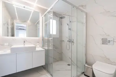 a bathroom with a glass shower and a sink at Luxury Apartment next to the National Museum in Athens