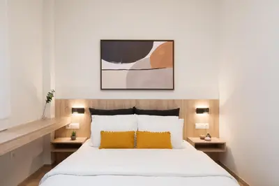 a bedroom with a bed with white sheets and yellow pillows at Luxury Apartment next to the National Museum in Athens