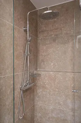 a shower with a glass door in a bathroom at Luxury Apartment next to the National Museum in Athens