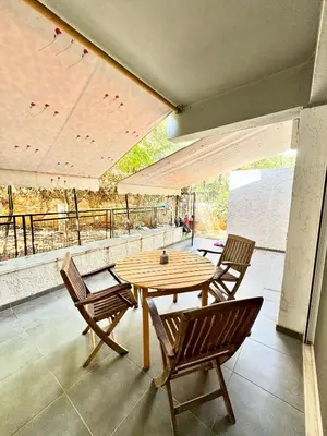 a wooden table and chairs on a patio at Varkiza Stay in Varkiza