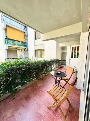 a patio with a table and a chair on a balcony at Varkiza Stay in Varkiza