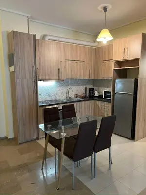 a kitchen with a table with chairs and a refrigerator at Thissio Apartment by Life Houses in Athens
