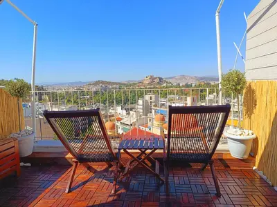 a patio with two chairs and a table on a balcony at Rooftop studio with Acropolis view just next to Panathenaic Stadium - 280 Athens view in Athens