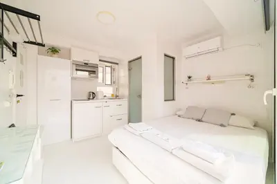 a white room with a bed and a kitchen at Rooftop studio with Acropolis view just next to Panathenaic Stadium - 280 Athens view in Athens