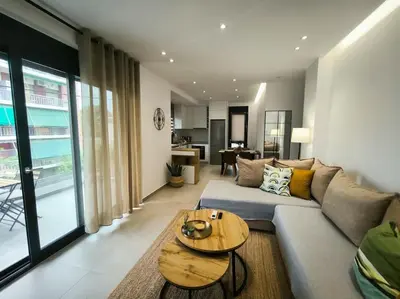 a living room with a couch and a table at Floral Home 2 - 1st floor apt with private parking! in Athens