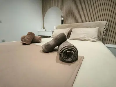 a large white bed with pillows and blankets on it at Floral Home 2 - 1st floor apt with private parking! in Athens