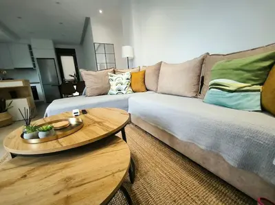 a living room with a couch and a table at Floral Home 2 - 1st floor apt with private parking! in Athens