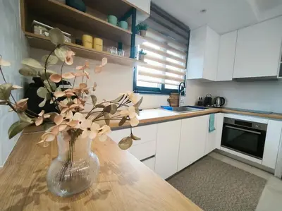 a vase with flowers on a table in a kitchen at Floral Home 2 - 1st floor apt with private parking! in Athens