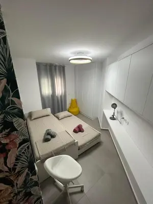 a small room with two beds and a chair at Floral Home 2 - 1st floor apt with private parking! in Athens