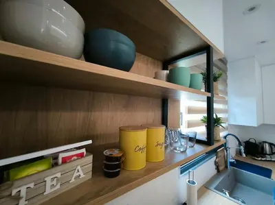a kitchen with two yellow trash cans on a shelf at Floral Home 2 - 1st floor apt with private parking! in Athens