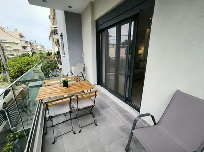 a table and chairs on the balcony of a building at Floral Home 2 - 1st floor apt with private parking! in Athens