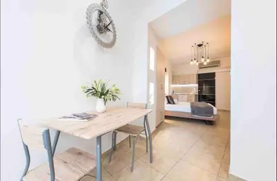 a dining room with a table and a bedroom at Studio In The Heart Of Kallithea in Athens