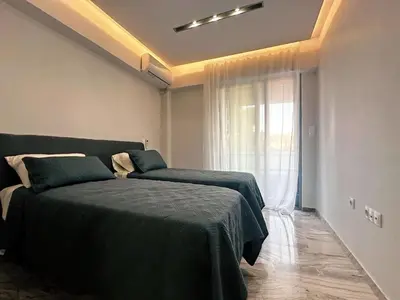 a bedroom with two beds and a window at Seaside Charming Apartment in Alimos in Athens