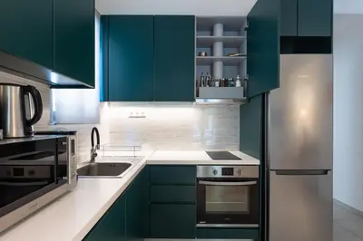 a kitchen with green cabinets and a stainless steel refrigerator at Elvis 2-Bedroom Apartment in Athens in Athens