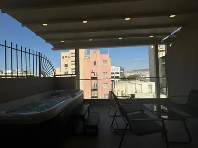 a bathroom with a tub and chairs and a large window at BlueMotion - PortSuite 4A in Piraeus