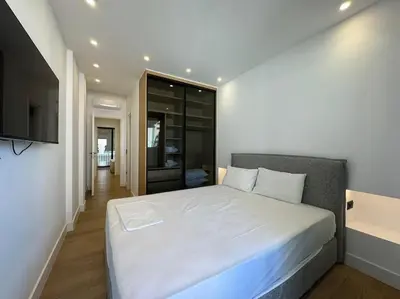 a bedroom with a white bed and a television at BlueMotion - PortSuite 4A in Piraeus