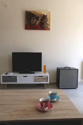 a living room with a tv and a table with two cups at Fly me to the moon! in Athens